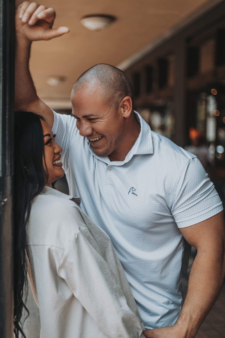 A woman smiling naturally during a professional photoshoot outdoors.